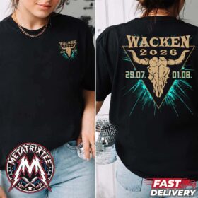 A woman wearing the Wacken Open Air 2026 Triangle Tee, a black two-sided t-shirt featuring a stylized bull skull inside a gold triangle with blue energy rays.