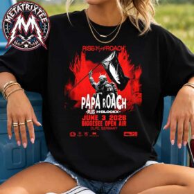 A woman wearing a black Olpe Germany Papa Roach Poster For Biggesee Open Air On June 3 Rise of The Roach Tour 2026 Vintage T-Shirt with a striking red graphic print.