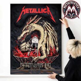 A hand hanging a premium canvas print of the Metallica Chorzow 2026 poster by Karol Banach, featuring a fierce dragon wrapped around Stadion Slaski amidst red flames under the M72 World Tour banner.